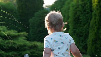 Wall Mural - Cute little girl spending time at backyard, camera following after child