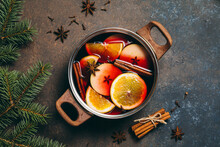 Hot Mulled Wine Cooking At Home For Happy Christmas Time. Red Wine, Orange, Apple And Spices - Ingredients Boiling In A Pot On Dark Background. Warming New Year And Holiday Drink, Flat Lay.