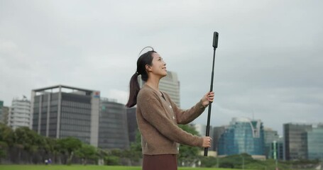 Canvas Print - Woman use 360 degree camera to take video at park