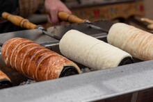 Traditional Hungarian chimney cake in the making,made from a sweet yeast dough that is rolled into a long rope and baked around a cylinder, sprinkled with cinnamon and sugar