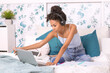 © ADDICTIVE STOCK - Woman studying with laptop sitting on bed