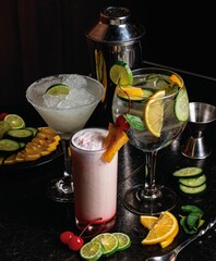 Poster - Vertical closeup shot of delicious exotic colorful cocktails surrounded by ingredients