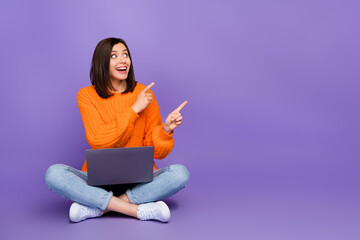 Wall Mural - Full length photo of nice young woman netbook point empty space dressed stylish knitted orange outfit isolated on purple color background