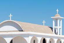 Closeup Of Traditional White Greek Orthodox Church In Cyprus Against Blue Sky