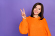 Leinwandbild Motiv Portrait of positive adorable girl beaming smile hand fingers demonstrate v-sign isolated on purple color background