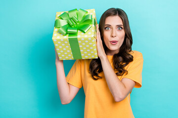 Poster - Portrait photo of young surprised funny face girl wavy hairstyle hold big package gift pouted lips reaction unexpected reaction isolated on cyan color background