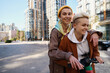 © Viacheslav Yakobchuk - Cheerful young women, lgbt couple, ride on scooter in big city