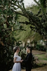 Wall Mural - Vertical of a lesbian pair with a bride and a female holding each others hand and looking each other