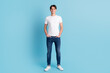© Tetiana - Full body picture of casual man with hand in pocket on blue color background