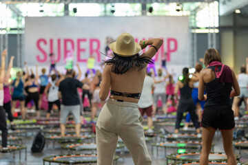 Wall Mural - Single Rebounder Workout - People doing Fitness Exercise in Class at Gym with Music and Teacher on Stage