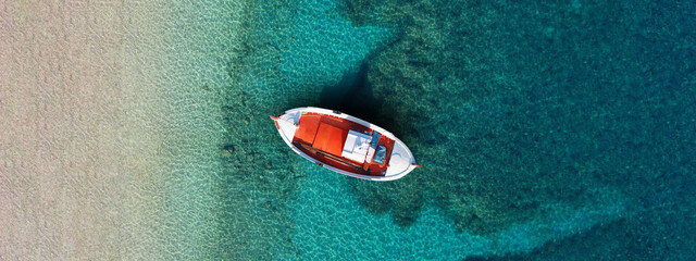 Wall Mural - Aerial top view photo of colourful traditional wooden fishing boat anchored in Aegean island destination port with turquoise sea