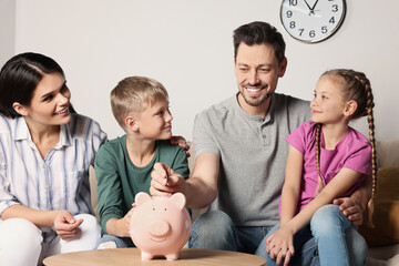 Sticker - Happy family putting coin into piggy bank at home