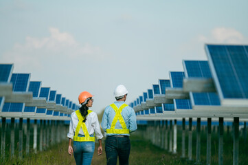 Asian Young Inspector Engineer man and female walking checking operation in solar farm