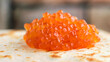 a hill of red salmon caviar rises above porous wheat pancakes