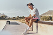 © Clement C/peopleimages.com - Skateboard, fitness and recreation with a sports man sitting on a wall at a skatepark during the day. Exercise, training and skating with a male athlete or skater having fun outdoor in summer