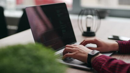Wall Mural - close up of freelancer's hands typing code on laptop keyboard. camera slides around developer's fige