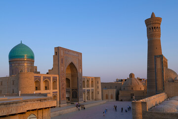 Wall Mural - Mir-i-Arab madrasah and Poi-Kalon minaret on a evening twilight. Historical,  center of Bukhara, Uzbekistan