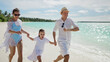 © Andrey Popov - Family Running Together On Beach