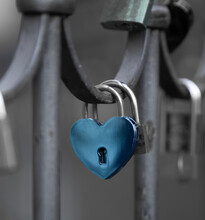 A Blue Heart-shaped Lock Hangs On The Fence