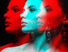 Beautiful And Sexy Looking Woman With Fancy Earrings With Gemstones Studio Portrait In RGB Color Split. RGB Effect Make Reflection Of Model Face In Red And Blue Colors. Abstract And Futuristic Style