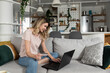 © Srdjan - Young happy woman online booking and making reservation for hotel with credit card. Female online shopping and ordering new clothes with home delivery service.