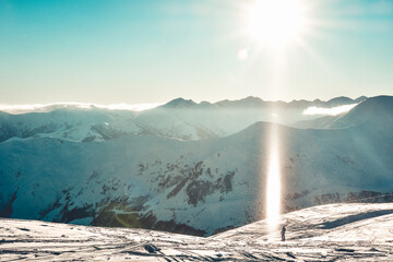 Wall Mural - Caucasus mountains wide panorama in sunny day with snow crystals in air and skier stand enjoy holidays on piste. Gudauri Georgia travel winter destination