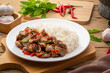 Stir-fried Chicken Giblets(livers, heart and gizzards) with Chillies and basil in white plate with cooked rice