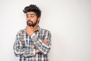 young hispanic bearded man wearing plaid shirt over white background with positive expression, has broad interested smile. Look there, please.looking for something or found something