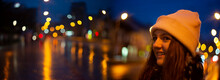 Girl In Christmas Traditional Market Decorated With Holiday Lights In The Evening. Beautiful Night With Blur Lights And Colors. Artistic Photography With Nice Blured Light Bokeh.