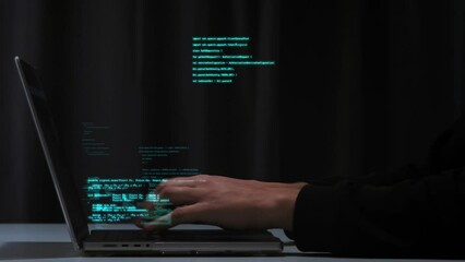 pogrammer's hands quickly type computer code on a laptop keyboard. hologram code shows up in differe