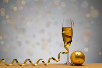 photo of two champagne glasses on brown table with christmas ball