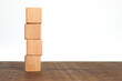 Four empty wooden cube blocks stack on the table on white background with copy space. Pile of wood bricks building construction. Mockup composition for design.