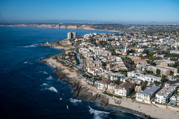 Wall Mural - Aerial image of Children's Pool by Seal Rock in La Jolla San Diego California with mountains in the background and palm tree lined roads