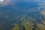 Fototapeta Do pokoju - White wind mills in a row on a top of a mountain green landscape in Spain, seen from an airplane