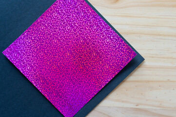 purple glitter paper on black paper and wood