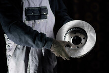 New Brake Disc In The Hands Of An Auto Mechanic In A Car Service