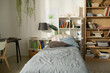 © Mediaphotos - Horizontal image of child bedroom with modern design with cozy bed, bookcase and desk in the corner of room