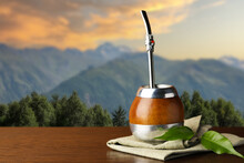 Calabash With Mate Tea And Bombilla On Wooden Table Outdoors At Sunset. Space For Text