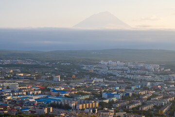 Morning cityscape. Top view of the buildings and streets of the city. Residential urban areas at sunrise. Koryaksky volcano in the distance. Petropavlovsk-Kamchatsky, Kamchatka Krai, Russian Far East.