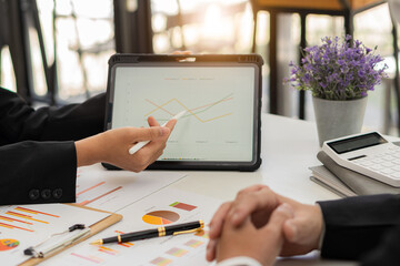 
Business consultants analyze financial figures showing the progress of financial business, accounting, contracts, investment advisory Consulting company marketing plans using tablets and technology.