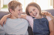 Children, siblings and hug on sofa laughing for sister and brother fun relaxing together at home. Happy portrait smile of kids in funny sibling bonding and enjoying time on the living room couch