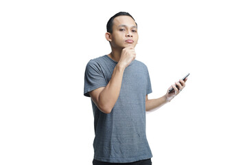 Young smiling handsome Asian man in casual attire using mobile phone isolated studio background