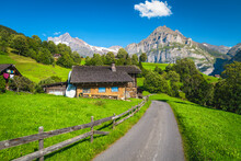 Narrow Mountain Road And Small House On The Green Field