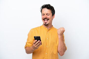 Wall Mural - Young man with moustache isolated on white background with phone in victory position