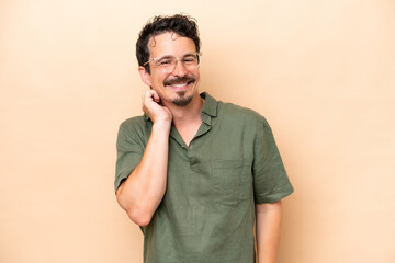 Wall Mural - Young caucasian man isolated on beige background laughing