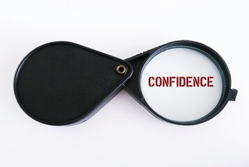 Magnifying glass on white background focus on word CONFIDENCE, concept of to overcome insecurity by increasing self trust and belief in abilities