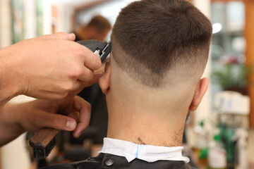 Wall Mural - Professional hairdresser working with client in barbershop, closeup