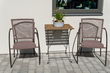 Little table and chairs on the veranda on a sunny day, relaxing zone. Cozy and comfortable atmosphere.