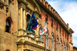 The flags of Europe, Italy and England above the entrance to Bologna City Hall