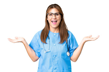 Canvas Print - Middle age nurse woman over isolated background with shocked facial expression